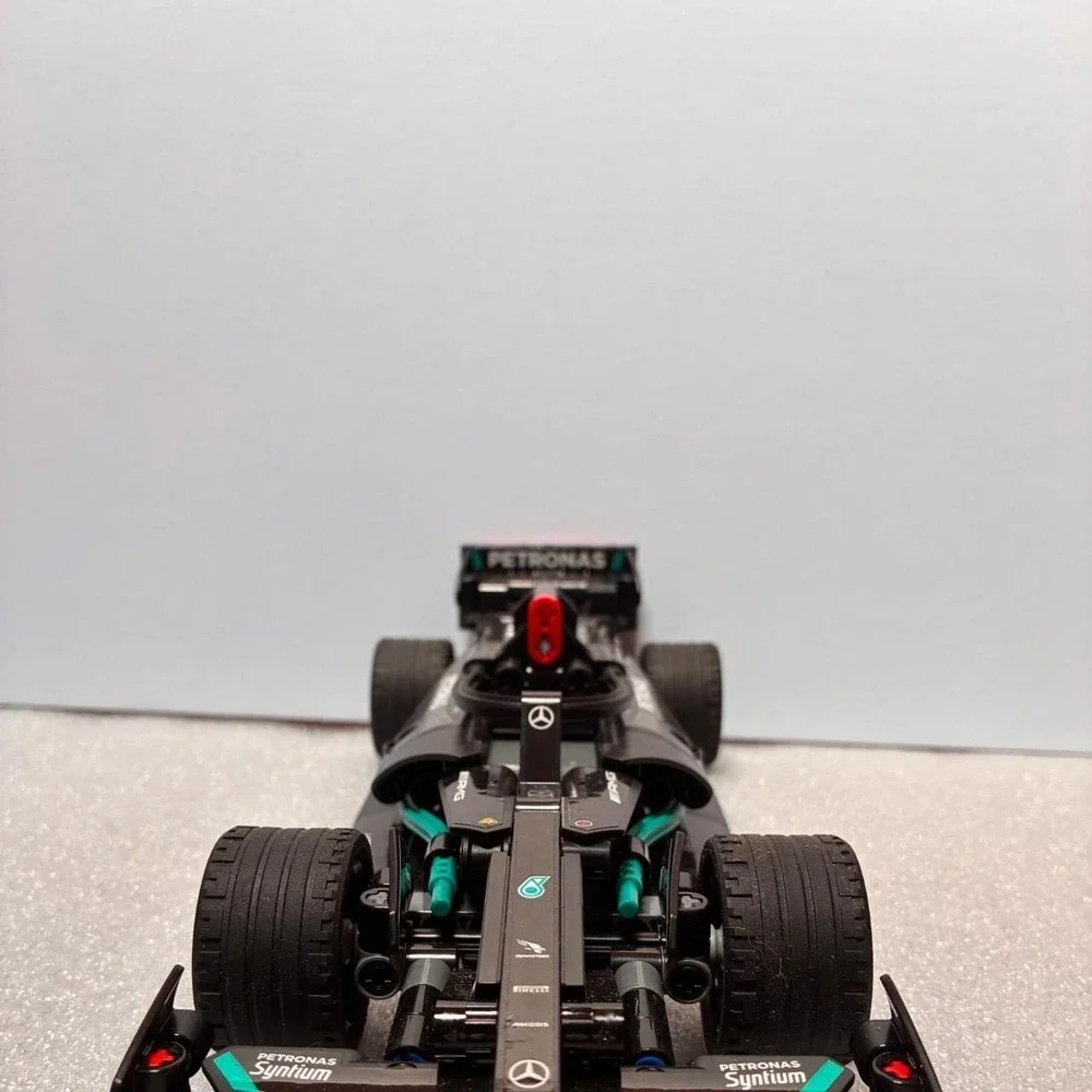 Mercedes F1 car model with green accents and Petronas